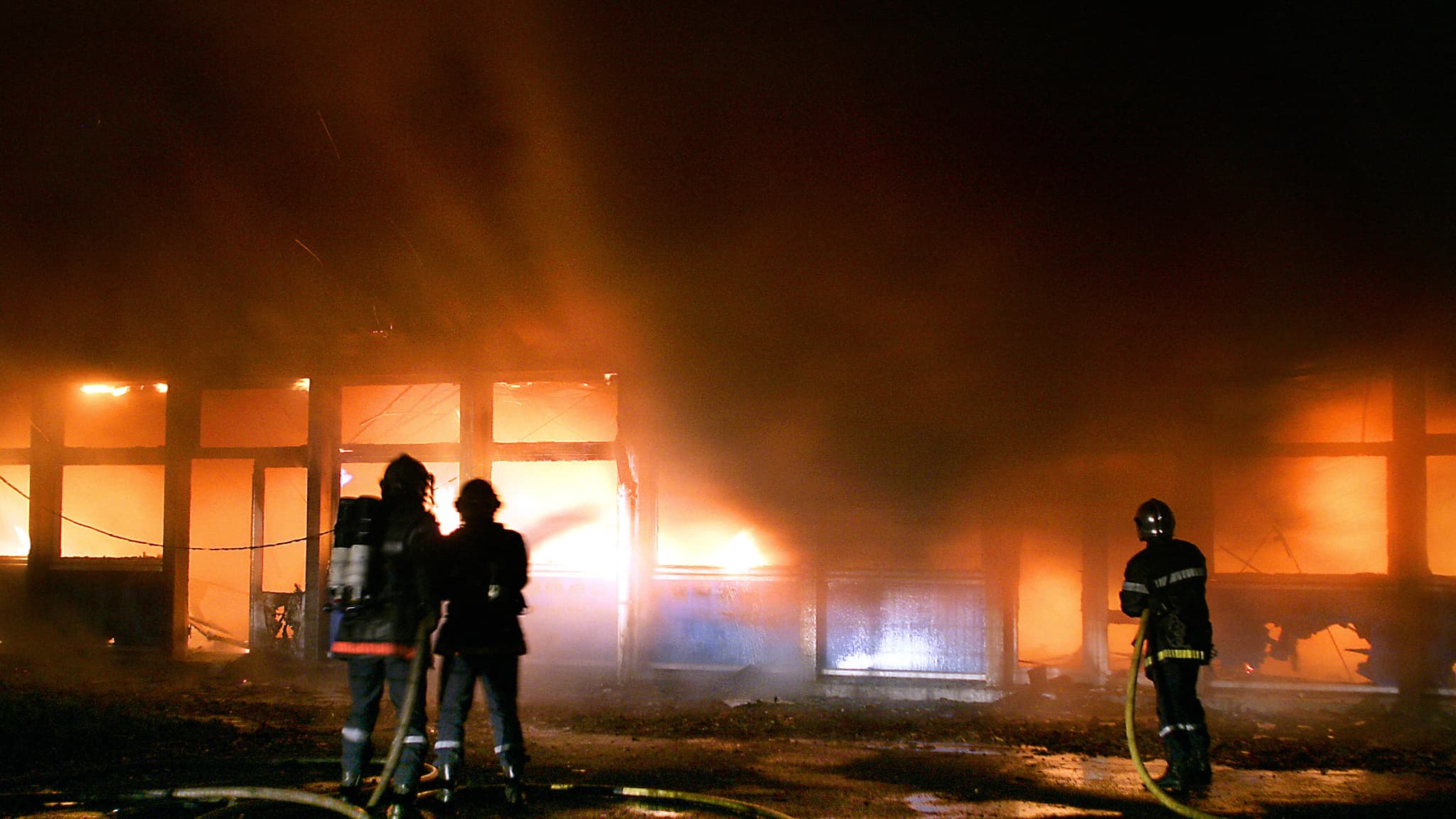 Des pompiers tentent d'éteindre un incendie le 8 novembre 2005 dans une école maternelle à Lille.