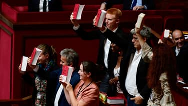 Des députés de la France insoumise brandissent le code du Travail à l'Assemblée nationale.