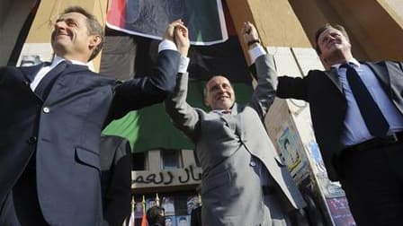 Nicolas Sarkozy et le Premier ministre britannique David Cameron (à droite) accueillis en héros à Benghazi, mi-septembre, par le chef du Conseil national de transition libyen, Moustapha Abdeljalil. Trois ans après la réception de Mouammar Kadhafi à l'Elys