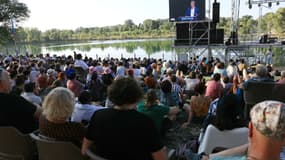 Des spectateurs se rassemblent pour regarder Jean-Luc Mélenchon, fondateur du parti de gauche La France Insoumise (LFI), s'afficher sur un écran lors de son discours à l'"Amfis 2024", à Châteauneuf-sur-Isère, dans le sud-est de la France, le 23 août 2024.
