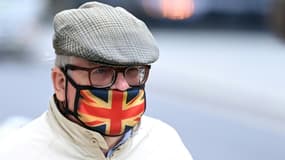 Un passant porte un masque de protection contre le Covid-19 aux couleurs du drapeau britannique, le 30 septembre 2021 à Londres