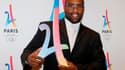 Teddy Riner pose avec le logo de candidature de Paris 2024