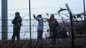 Des migrants marchent le long des rails sur le site de Calais-Frethun.