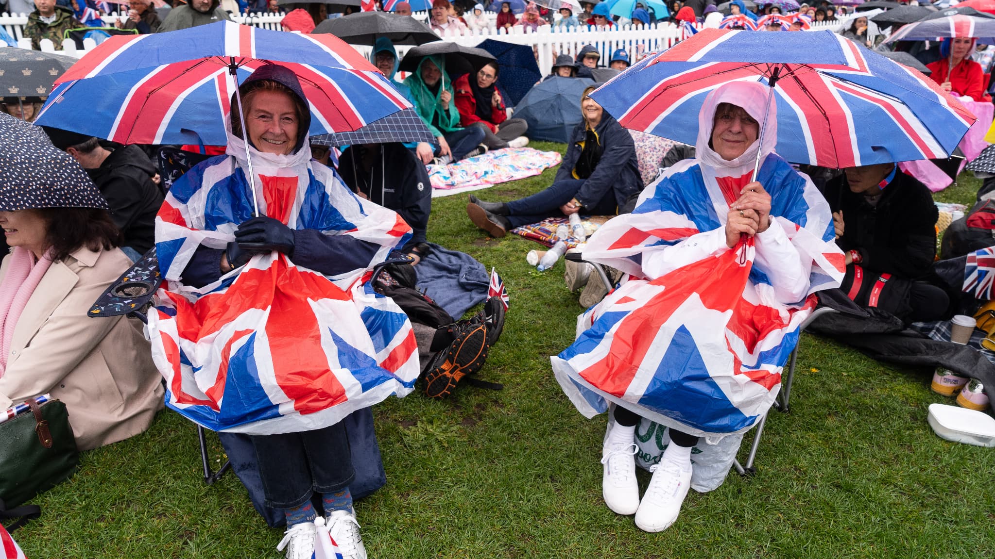 Les spectateurs attendent avec leur parapluie.