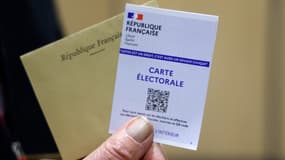 Une personne présente son bulletin de vote et sa carte électorale, dimanche 12 juin 2022, lors du 1er tour des élections législatives au Touquet.