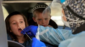 Un médecin pratique un test Covid sur un enfant dans un centre de dépistage de Jérusalem, le 29 juillet 2021