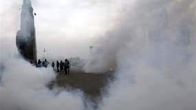 Opposants à Mohamed Morsi entourés de gaz lacrymogène près de la place Tahrir, au Caire. Le président égyptien a déclaré l'état d'urgence pendant trente jours dans trois villes du canal de Suez, où des violences de ces quatre derniers jours ont fait des d