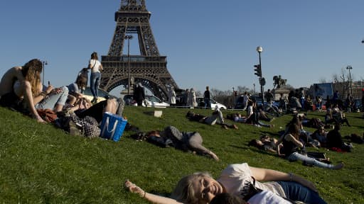 Des Parisiens prennent le soleil non loin de la tour Eiffel, dimanche 9 mars.