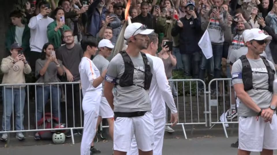 Eve Gilles donne le relais de la flamme olympique à Dany Boon à Lille le 2 juillet 2024