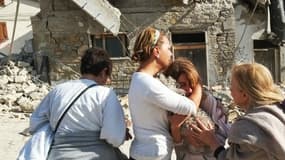 Une femme pleure devant des maisons effondrées dans le village d'Illica, près d'Accumoli, au lendemain du séisme qui a frappé l'Italie.
