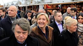 Marine Le Pen accompagnée du président de son comité de soutien, l'avocat Gilbert Collard, sur le marché de Noël des Champs-Elysées. Dénonçant "l'incohérence" des Verts, la candidate du Front national à l'élection présidentielle s'est posée lundi en chant