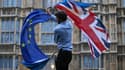 Un homme agitant un drapeau européen et britannique devant les chambres du Parlement