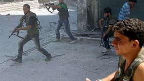 Combattans de l'Armée libre syrienne dans le centre d'Alep. L'armée syrienne, appuyée par des chars et un hélicoptère de combat, poursuit son offensive contre les positions rebelles dans la capitale économique du pays. /Photo prise le 5 août 2012/REUTERS/