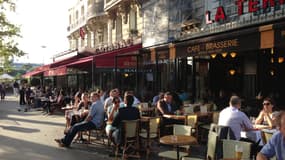 Des personnes attablées en terrasse sous le soleil à Paris (Photo d'illustration)