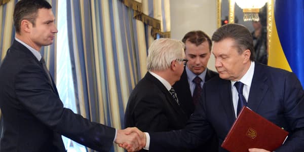 L'opposant Vitali Klitschko et le président Viktor Ianoukovitch se serrent la main après la signature de l'accord, à Kiev, le 21 février.