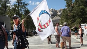 Un partisan de Donald Trump brandit un drapeau de la mouvance conspirationniste QAnon devant le mont Rushmore (Dakota du sud), le  1er juillet 2020