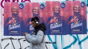 Un passant devant une affiche de Christiane Taubira en janvier 2022 à Paris 