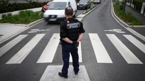 Un gendarme contrôle le trafic à Montreuil-Juigné (Maine-et-Loire), le 4 juillet 2023, durant les recherches pour retrouver un fugitif soupçonné d'un double meurtre.