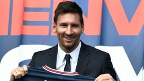 La recrue star du PSG Lionel Messi pose avec son nouveau maillot, le 11 août 2021 au Parc des Princes à Paris     