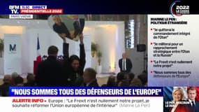 Une militante brandissant une photo de Marine Le Pen et de Vladimir Poutine trainée au sol lors de la conférence de presse