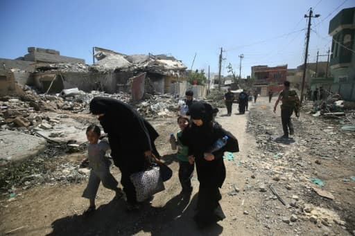 Une famille fuit les combats entre les forces de sécurité irakiennes et les jihadistes de l'EI, le 17 mai 2017 à Mossoul-Ouest Une famille fuit les combats entre les forces de sécurité irakiennes et les jihadistes de l'EI, le 17 mai 2017 à Mossoul-Ouest