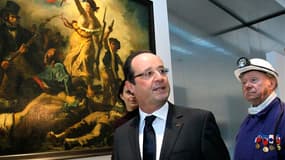 François Hollande et un ancien mineur, devant "La Liberté Guidant le Peuple, 1830" de Delacroix. Le président a inauguré mardi le musée Louvre-Lens. /Photo prise le 4 décembre 2012/REUTERS/Michel Spingler/Pool