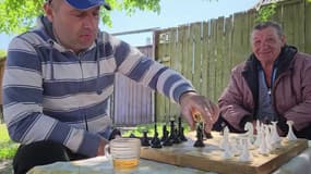 Des hommes jouent aux échecs, dans la ville de Vovtchansk, le 4 juin 2023.