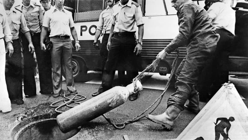 Un policier retire une bouteille à oxygène des égouts de Nice le 20 juillet 1976. Suite au cambriolage de la Société Générale de Nice effectué par les égouts de la ville, les policiers ont récupéré tout l'arsenal utilisé pour le "casse du siècle" par le gang des égoutiers.
