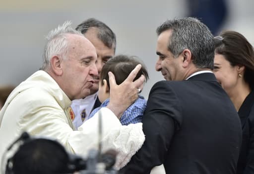 Le pape François embrasse un garçon à son arrivée  à l'aéroport de Quito le 5 juillet 2015