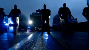 Des gendarmes formant un barrage devant leurs fourgon à la tombée de la nuit, à Gien (Loiret) le 1er février 2024.