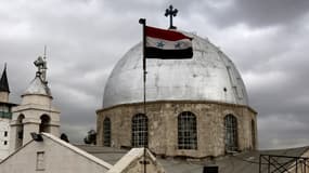 Le drapeau syrien flotte devant une église dans la capitale du pays, Damas. (photo d'illustration)