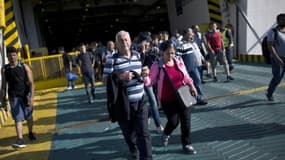 Des migrants débarquent au port du Pirée, le 29 août 2015, en Grèce