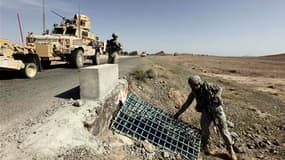 Soldats américains inspectant les fossés à la recherche d'"IED", sur une route de Kandahar. Ces bombes artisanales, rudimentaires et bon marché, que les militaires nomment engins explosifs improvisés, se multiplient depuis 2007 en Afghanistan. /Photo pris