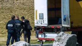 Des policiers sortent un migrant d'un camion dans lequel il avait trouvé refuge, au port de Calais le 16 juin 2015.