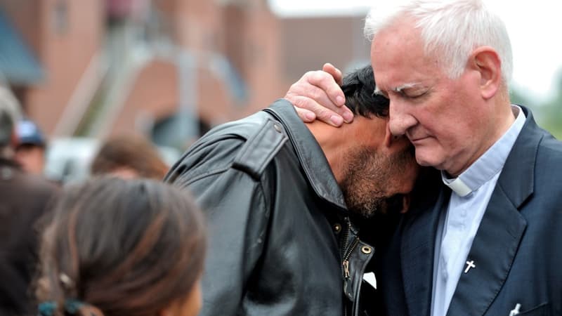 Le père Arthur, en 2012, conforte un homme expulsé de son camp par les forces de police