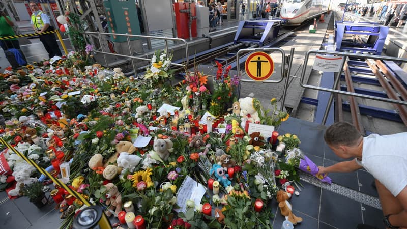 Un homme déposant des fleurs sur le lieu de l'homicide