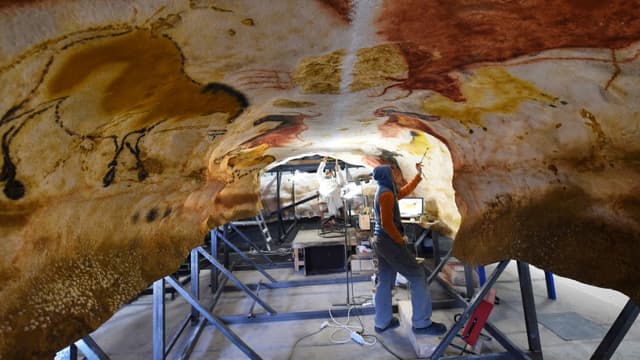Des artistes travaillent sur la réplique de la Grotte de Lascaux.