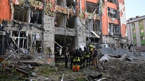 Des pompiers inspectent un immeuble de bureaux lourdement endommagé à la suite d'une attaque aérienne russe à Kharkiv, le 25 mai 2024.