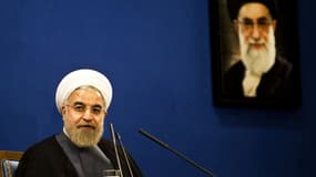 Le Président iranien Hassan Rohani, assis devant un portrait du guide suprême Ali Khamenei lors d'une conférence de presse à Téhéran