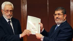 Le président Morsi (D) reçoit une copie de la nouvelle constitution.