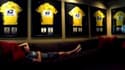 Lance Armstrong posant chez lui devant ses sept maillots jaunes, après qu'ils lui ont été retirés