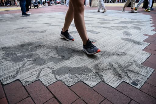 Des habitants de Hong Kong foulent le 2 juin 2020 un trottoir dont les pavés ont été remplacés par du béton par les autorités locales, en réponse aux manifestations pro-démocratie. Des habitants de Hong Kong foulent le 2 juin 2020 un trottoir dont les pavés ont été remplacés par du béton par les autorités locales, en réponse aux manifestations pro-démocratie.