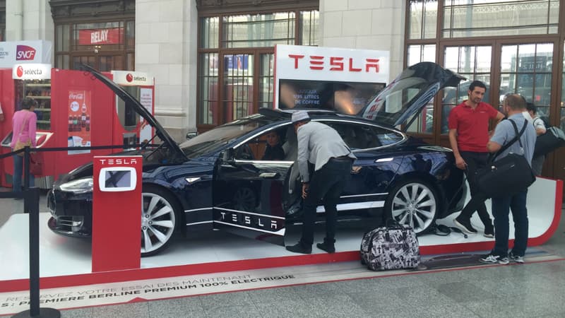 Les passants se pressent autours de la Tesla Model S exposée à la gare de Lyon à Paris jusqu'au 6 septembre prochain