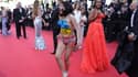 Une femme, torse nu peint aux couleurs du drapeau ukrainien avec la mention en anglais "arrêtez de nous violer", sur le tapis rouge du Festival de Cannes, le 20 mai 2022.