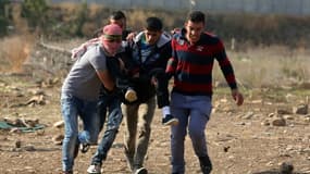 Des Palestiniens portent l'un des leurs, blessé, après des heurts avec des soldats israéliens à Tulkarem (Cisjordanie), le 11 novembre 2015