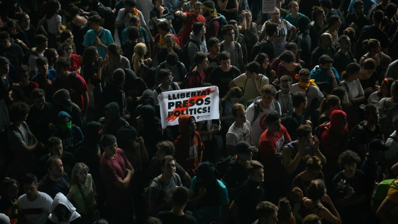 Un manifestant tient une pancarte disant "Libérez les prisonniers politiques", au milieu d'une foule à l'aéroport de Barcelone, le jour de l'annonce des peines d'indépendantistes catalans