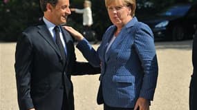 Angela Merkel et Nicolas Sarkozy avant une réunion à l'Elysée. France et Allemagne proposent plusieurs mesures pour régler la crise de la dette en Europe, notamment la création d'une taxe commune sur les transactions financières et la création d'un "gouve