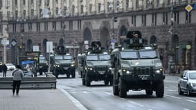 Des véhicules militaires ukrainiens passent près de la place de l'Indépendance à Kiev, le 24 février 2022 après l'invasion de la Russie en Ukraine