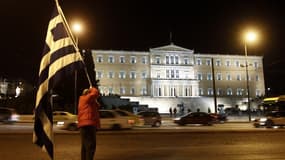 Un manifestant devant le parlement grec, à Athènes, vendredi. Les ministres des Finances de la zone euro devraient approuver ce lundi un deuxième plan d'aide en faveur de la Grèce d'un montant de 130 milliards d'euros, crucial pour redonner de l'air au pa