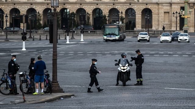 Des forces de l'ordre en train de contrôler un individu en scooter à Paris au premier jour du confinement au moins de mars 2020.